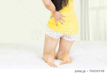 Attractive woman with back pain at home in the bedroom,This bed is not comfortable as I thought,female with waist pain Attractive woman with back pain at home in the bedroom,This bed is not comfortable as I thought,female with waist pain 70030749