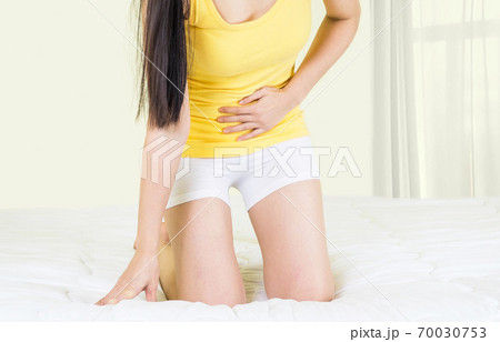 Young upset unhappy woman suffering from menstruation pain, PMS at home. Abdomen and stomach pain during criticals days. Health problems Young upset unhappy woman suffering from menstruation pain, PMS at home. Abdomen and stomach pain during criticals days. Health problems 70030753