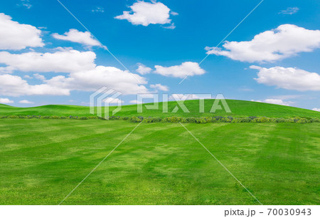 green field and blue sky with light clouds,Image of green grass field and bright blue sky. Plain landscape background for summer poster. 70030943