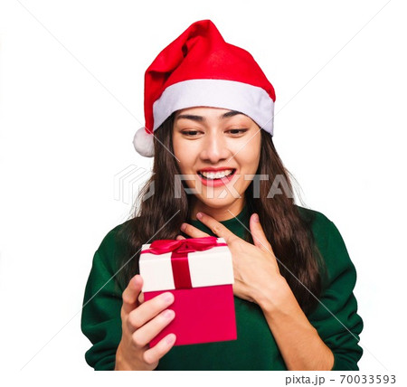 Selective focus Young beautiful asian woman wore green sweater and santa hat,Excited, surprised and happy, Holding a gift box with a bow isolated on white background,Christmas day and New Year's gifts 70033593
