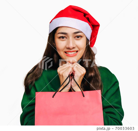 Selective focus Young beautiful asian woman wore green sweater and santa hat,Excited, surprised and happy, Holding a gift box with a bow isolated on white background,Christmas day and New Year's gifts Selective focus Young beautiful asian woman wore green sweater and santa hat,Excited, surprised and happy, Holding a gift box with a bow isolated on white background,Christmas day and New Year's gifts 70033603