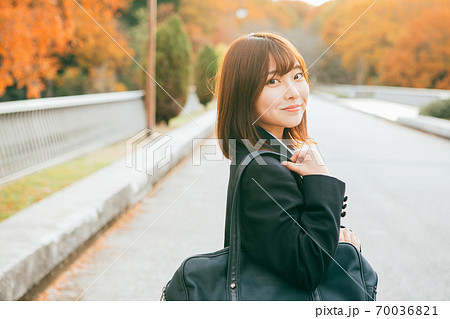 紅葉した街を歩く女子高生 70036821