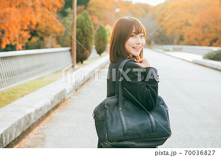 紅葉した街を歩く女子高生 70036827