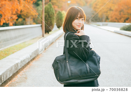 紅葉した街を歩く女子高生 70036828