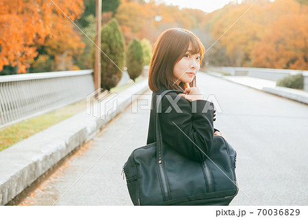 紅葉した街を歩く女子高生 70036829