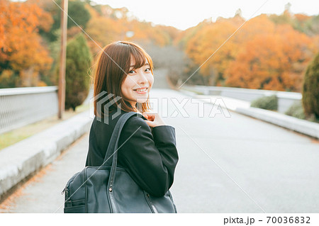 紅葉した街を歩く女子高生 70036832