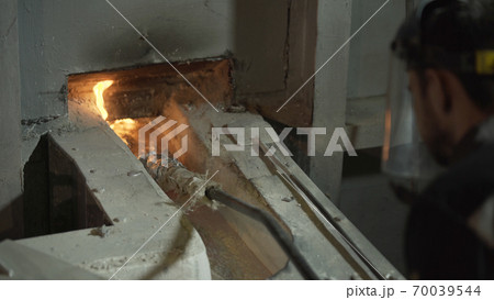 Liquid aluminium is overflowing in Metallurgical plant. Making engine, molten aluminium is casting in form in aluminum profile factory. 70039544
