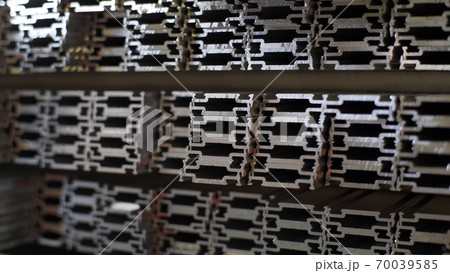 Close up shot of aluminium profiles. Aluminium production line factory warehouse stack of profiles. Heavy metallurgical industrial products, manufacturing business production concept Close up shot of aluminium profiles. Aluminium production line factory warehouse stack of profiles. Heavy metallurgical industrial products, manufacturing business production concept 70039585
