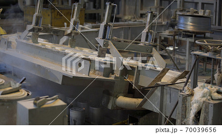 Forming aluminum column after melting in modern factory. Production of aluminium metal profiles, commonly used as material in construction and manufacturing. Forming aluminum column after melting in modern factory. Production of aluminium metal profiles, commonly used as material in construction and manufacturing. 70039656