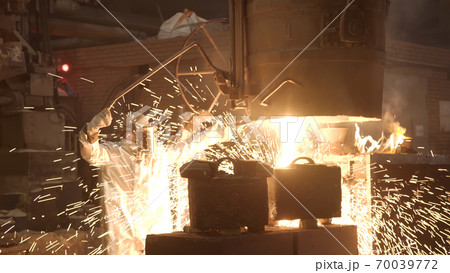 Metal smelting furnace in steel mill. Molten metal pouring, metallurgy, steel casting foundry. Furnace in which metal is melted. Metallurgical industry Metal smelting furnace in steel mill. Molten metal pouring, metallurgy, steel casting foundry. Furnace in which metal is melted. Metallurgical industry 70039772