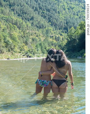 Rear view of two women standing into the river 70039814