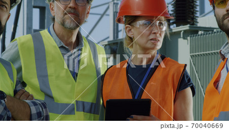 Mature engineer talking on smartphone during meeting on power station 70040669
