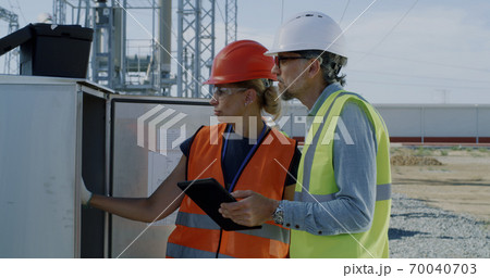 Engineers checking transformer box on power plant 70040703