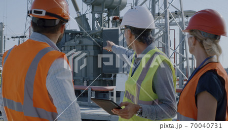 Female engineer discussing data on tablet with men 70040731