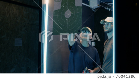 Male shooters examining target together 70041386