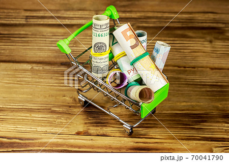 Shopping cart with money from different countries 70041790