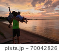 夕焼け空と海と親子 70042826