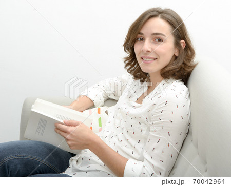 beautiful young woman with a book in the sofa beautiful young woman with a book in the sofa 70042964