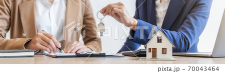Estate agent holding a key and asking costumer for contract to buy, get insurance or loan estate. Estate agent holding a key and asking costumer for contract to buy, get insurance or loan estate. 70043464