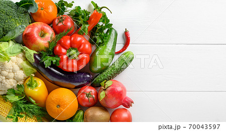 Mixed vegetables and fruits on the white wooden table, directly above, copy space. Mixed vegetables and fruits on the white wooden table, directly above, copy space. 70043597