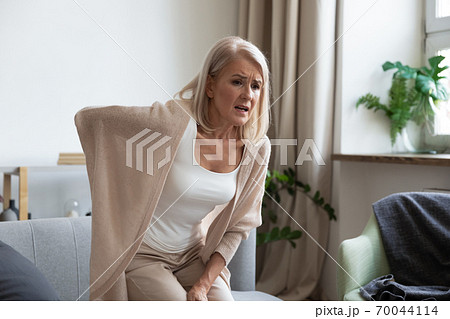 Worried upset mature woman feel hurt sudden back ache Worried upset mature woman feel hurt sudden back ache 70044114