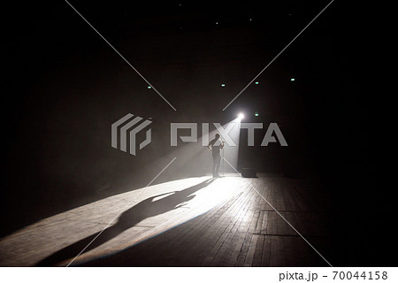 Stand up comedian on stage in the beam of light. Stand up comedian on stage in the beam of light. 70044158