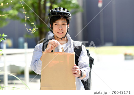 受け渡しをするデリバリーの配達員の男性 受け渡しをするデリバリーの配達員の男性 70045171