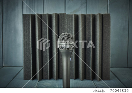 Dynamic microphone for vocals and choirs with acoustic foam in the background and wood in shades of gray and blue 70045336