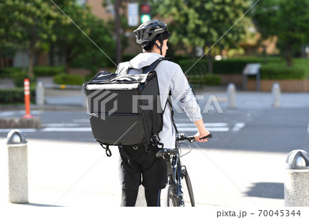 自転車で配達をするデリバリーの男性の後ろ姿 70045344