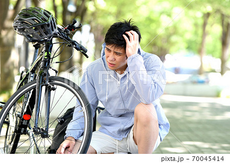 自転車のトラブルに困る若い男性 70045414