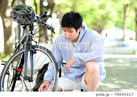 自転車のトラブルに困る若い男性 自転車のトラブルに困る若い男性 70045417
