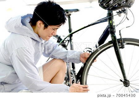 自転車のトラブルに困る若い男性 70045430