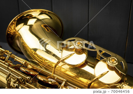 Bell and keys of a golden saxophone on gray wooden background 70046456
