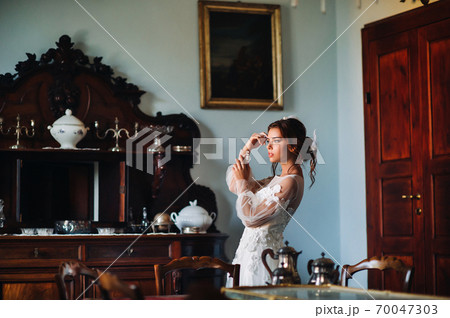 a bride in underwear and a white robe in the interior of a Villa in Italy at a wedding.morning of the bride in Tuscany.boudoir photo session at the Villa. 70047303