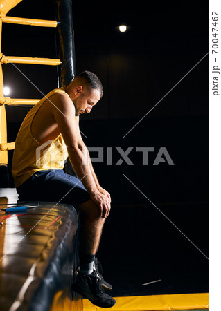Upset fighter resting with the hands on his knees Upset fighter resting with the hands on his knees 70047462