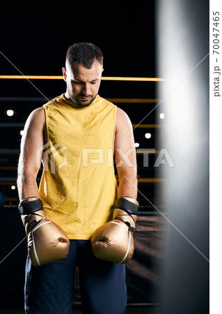 Sad boxing champion standing with his head down 70047465