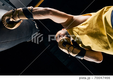 Boxer is striking a black sand bag Boxer is striking a black sand bag 70047466