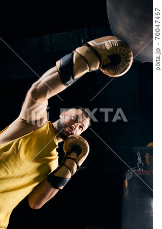 Fighter hitting a boxing bag with a left hook Fighter hitting a boxing bag with a left hook 70047467