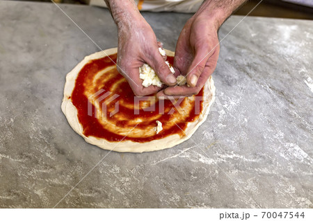 Cooking pizza. Pancake for pizza smeared with ketchup 70047544