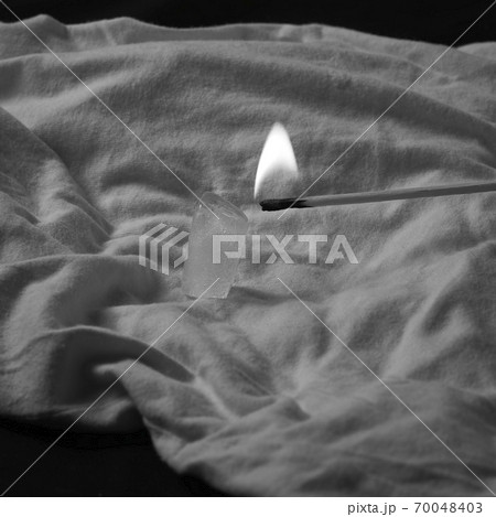 Burning match melting ice cube Burning match melting ice cube 70048403