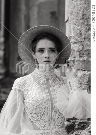 Pretty young caucasian redhead girl in garden and outside with wedding bouquet. 70048523