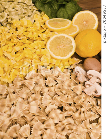 Dry Butterfly pasta with different flavors on a wooden background. Multi-colored pasta with spinach 70049557