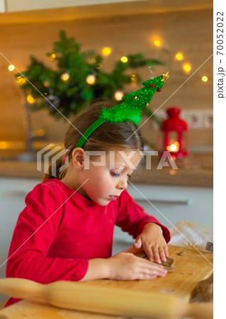 Happy little girl prepares cookies on the eve of christmas. Happy little girl prepares cookies on the eve of christmas. 70052022