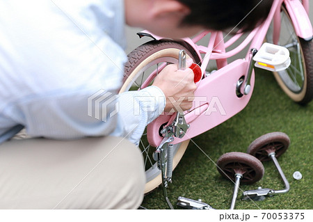 自転車の補助輪とスタンドを取り外しする男性 70053375