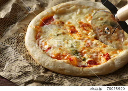 英字新聞に切り分けたピザ 70053990