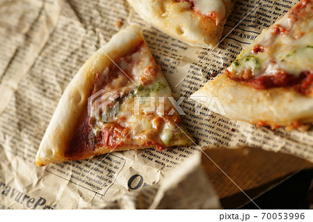 英字新聞に切り分けたピザ 70053996