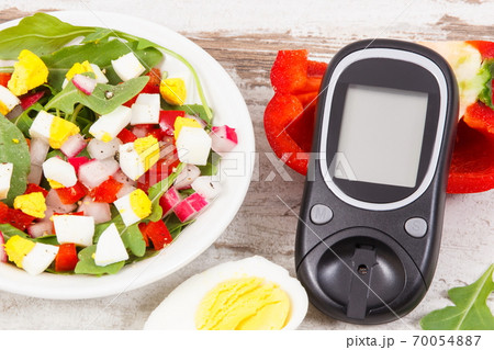 Glucometer for measurement sugar level and fresh salad with eggs and vegetables Glucometer for measurement sugar level and fresh salad with eggs and vegetables 70054887