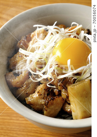 炭火で焼いた焼き鳥の上に白髪葱と卵黄を乗せた熱々の丼ぶり 炭火で焼いた焼き鳥の上に白髪葱と卵黄を乗せた熱々の丼ぶり 70056074