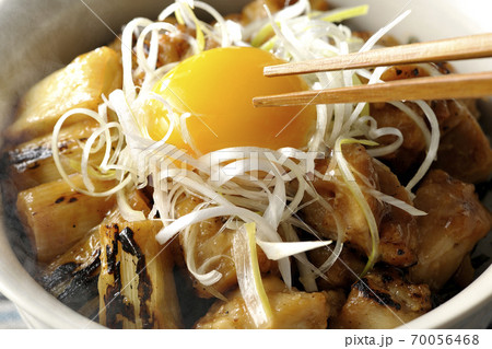 炭火で焼いた焼き鳥の上に白髪葱と卵黄を乗せた熱々ヤキトリ丼の黄身を箸で割って食べる 炭火で焼いた焼き鳥の上に白髪葱と卵黄を乗せた熱々ヤキトリ丼の黄身を箸で割って食べる 70056468