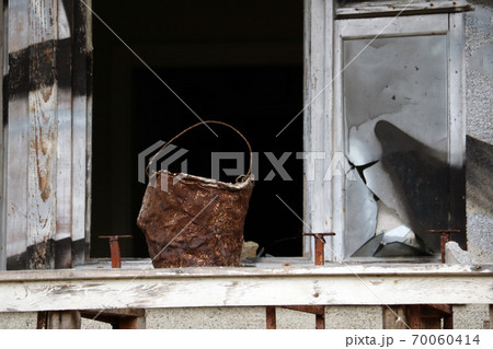 An old rusty bucket stands in the window. Fire extinguishing. An old rusty bucket stands in the window. Fire extinguishing. 70060414